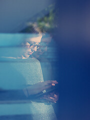 Image showing Woman using tablet at home by the window