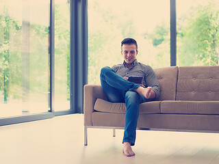 Image showing man on sofa using tablet computer