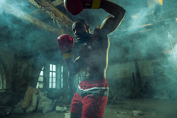 Image showing Hand of boxer over black background. Strength, attack and motion concept