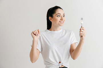 Image showing Young fun crazy brunette housewife with fork isolated on white background