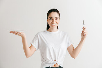 Image showing Young fun crazy brunette housewife with fork isolated on white background