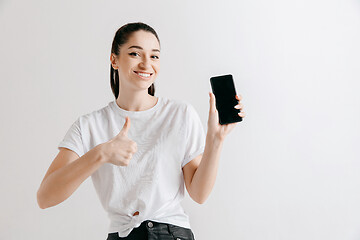 Image showing Portrait of a confident casual girl showing blank screen of mobile phone