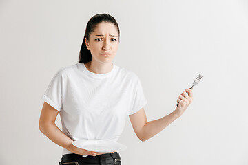 Image showing Young fun crazy brunette housewife with fork isolated on white background