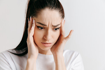 Image showing Woman having headache. Isolated over gray background.