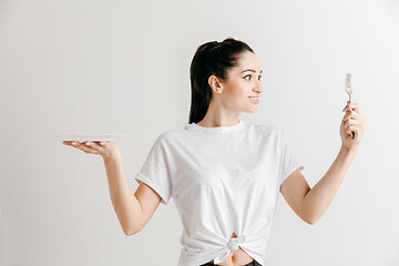 Image showing Young fun crazy brunette housewife with fork isolated on white background