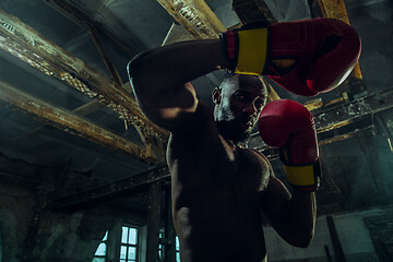 Image showing Hand of boxer over black background. Strength, attack and motion concept