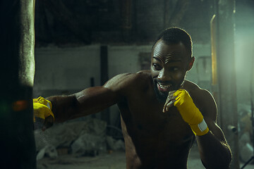 Image showing Hand of boxer over black background. Strength, attack and motion concept