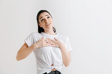 Image showing The happy woman standing and smiling against gray background.