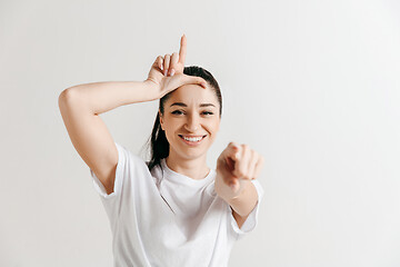 Image showing Losers go home. Portrait of woman showing loser sign over forehead