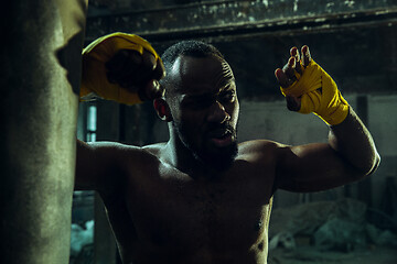 Image showing Hand of boxer over black background. Strength, attack and motion concept