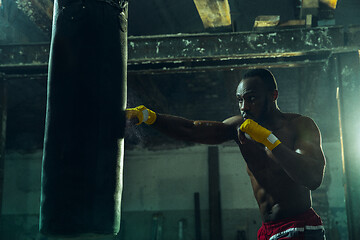 Image showing Hand of boxer over black background. Strength, attack and motion concept