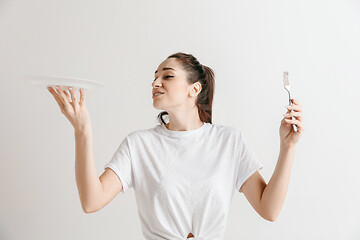 Image showing Young fun crazy brunette housewife with fork isolated on white background