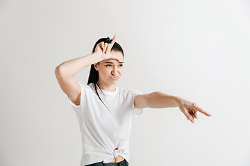 Image showing Losers go home. Portrait of woman showing loser sign over forehead