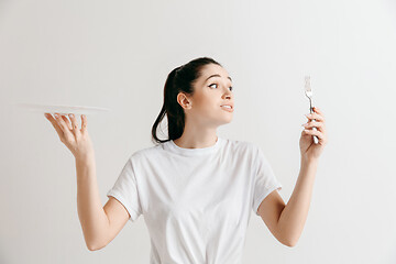 Image showing Young fun crazy brunette housewife with fork isolated on white background