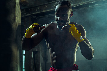 Image showing Hand of boxer over black background. Strength, attack and motion concept