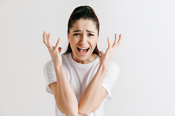 Image showing The young emotional angry woman screaming on gray studio background