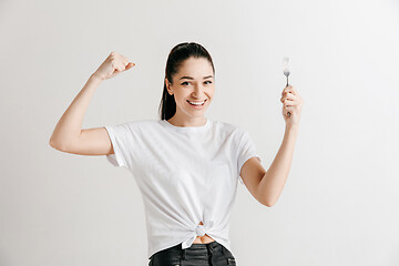 Image showing Young fun crazy brunette housewife with fork isolated on white background