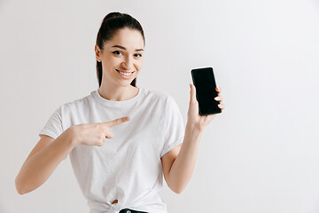 Image showing Portrait of a confident casual girl showing blank screen of mobile phone