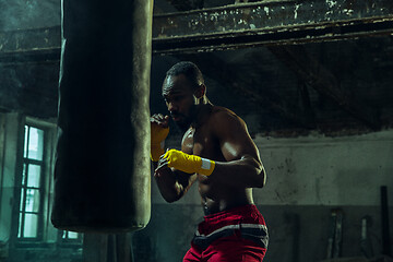 Image showing Hand of boxer over black background. Strength, attack and motion concept