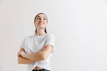 Image showing The happy woman standing and smiling against gray background.