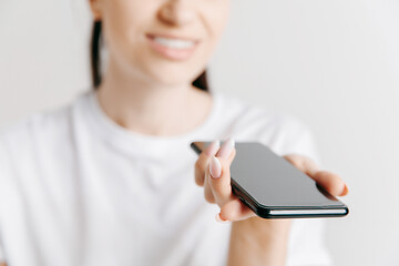 Image showing Indoor portrait of attractive young woman holding blank smartphone