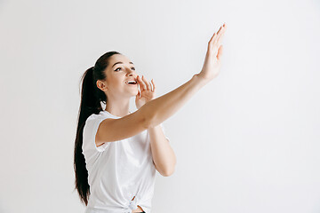 Image showing Isolated on gray young casual woman shouting at studio