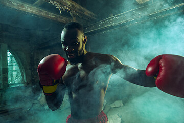 Image showing Hand of boxer over black background. Strength, attack and motion concept