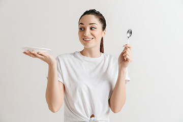 Image showing Young fun crazy brunette housewife with spoon isolated on white background