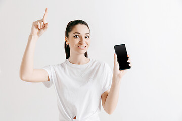 Image showing Portrait of a confident casual girl showing blank screen of mobile phone