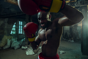 Image showing Hand of boxer over black background. Strength, attack and motion concept