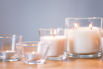 Image showing burning white fragrance candles on wooden table