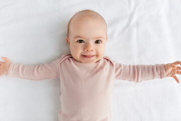 Image showing sweet baby girl lying on white blanket