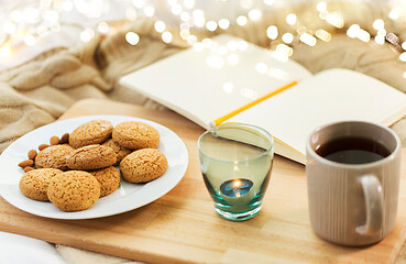 Image showing cookies, tea and candle in holder at home