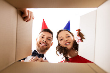 Image showing couple in party hats opening birthday gift box