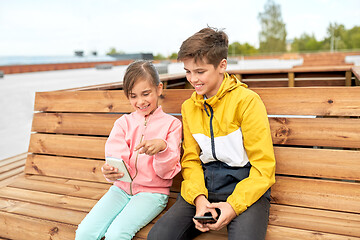 Image showing children with smartphones sitting on street bench