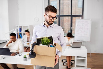 Image showing sad fired male office worker with personal stuff