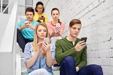 Image showing students with smartphones sitting on stairs