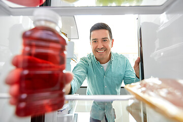 Image showing man taking juice from fridge at home kitchen