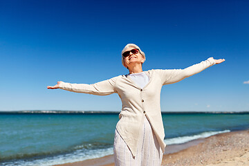 Image showing portrait of senior woman in sunglasses on beach