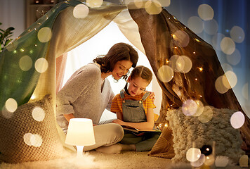 Image showing happy family reading book in kids tent at home