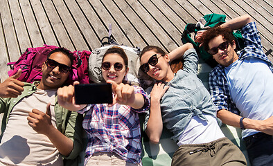 Image showing friends or tourists with backpacks taking selfie