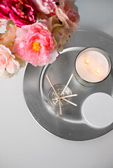 Image showing aroma reed diffuser, candle and flowers on table