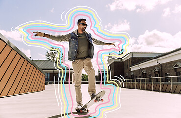 Image showing indian man doing trick on skateboard on roof top