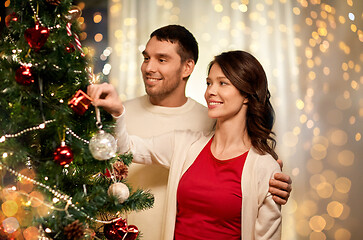 Image showing happy couple decorating christmas tree at home