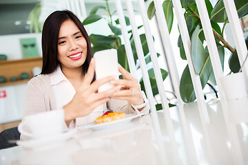 Image showing asian woman with smartphone at cafe or coffee shop