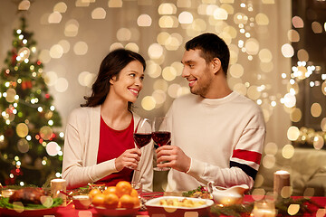 Image showing happy couple drinking red wine at christmas dinner