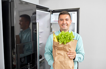 Image showing man with new purchased food at home fridge