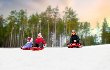 Image showing kids sliding on sleds down snow hill in winter