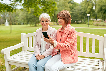 Image showing happy senior women with smartphone at summer park