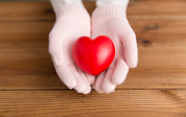 Image showing hands in pink woollen gloves holding red heart